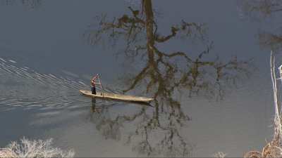 Fisherman travelling on a dugout on the lake