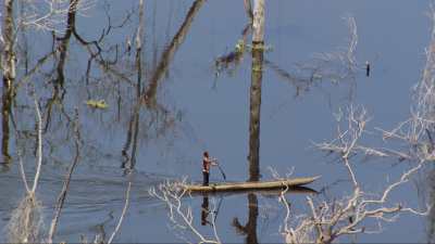 Fisherman travelling on a dugout on the lake