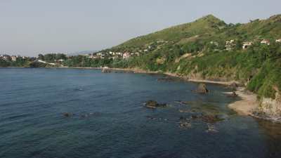 Small beach, bathers and beach umbrellas