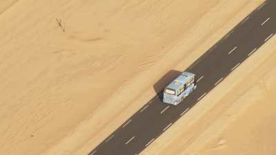 Colorful bus on the Saharan road crossing the desert