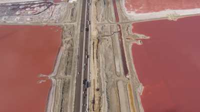 A raised motorway crosses pink Lake Mariout Salt marshes