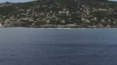 Flight over housing on the coast, near Genoa, and mountains