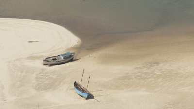 Fisherman boats travel along the sandbanks of the seashore