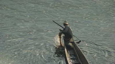 Pêcheur en pirogues en contre-jour