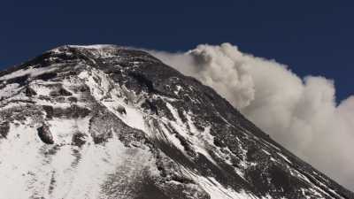 The snowy Popocatepetl, surrounded by blue sky and clouds