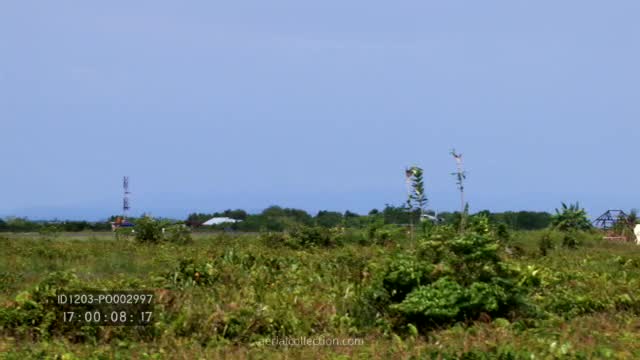 Small commercial aircraft landing at Sorong, motorcycles entering runway after its passage