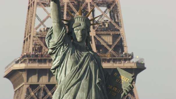 The Parisian Statue of Liberty and the Eiffel Tower, seen from a boat.